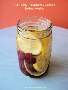 a mason jar filled with lemons, raspberries and lemonade