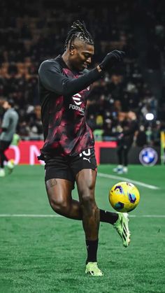 a man kicking a soccer ball on top of a field