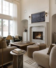 a living room filled with furniture and a fire place in the middle of a room