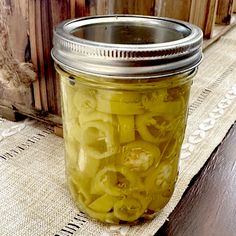 a jar filled with pickles sitting on top of a table