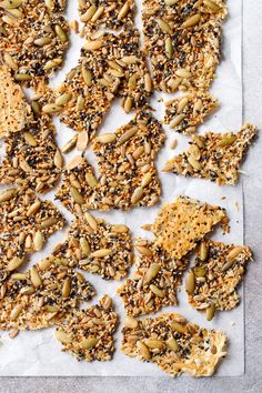 bird seed crackers are arranged on top of a piece of parchment paper with seeds scattered around them