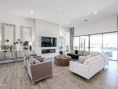 a living room filled with furniture and a flat screen tv mounted on the wall above a fireplace