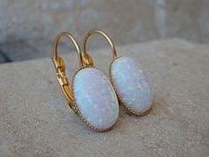 Bridal White Fire Opal Earrings for Bride Earrings, Oval Opal Earrings, October Birthstone Earrings, Leverback Gold Earrings, Opal Jewelry These stunning oval white opal leverback earrings have a great statement look that can't be missed. They would be great for women, bridesmaid or bride. Metal: 24K Gold Plate Gemstone: Opal lab Stone Size: 10mm X 14mm FOR MATCHING RING: https://www.etsy.com/il-en/listing/252232392/opal-gold-ring-gemstone-ring-white-opal?ref=shop_home_active_7 FOR ROUNDED WHITE Oval Clip-on Earrings For Gift, White Oval Earrings With Ear Wire, Oval Wedding Earrings With Lever Back Ear Wires, White Lever Back Earrings As Gift, White Lever Back Earrings For Gift, Opal Earrings Vintage, Earrings For Bride, Opal Earring, Fire Opal Earrings