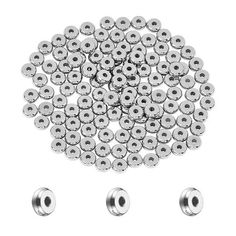 an assortment of metal balls and screws on a white background