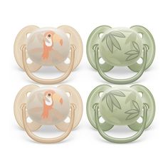 three pacifiers with leaves on them and one has a fish in the middle