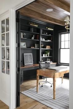 a home office with built in bookshelves and desk