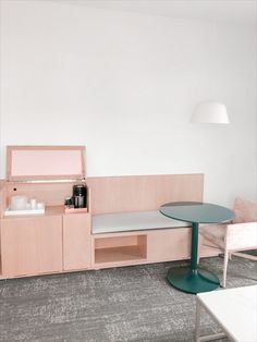 a table and chairs in a room with a light colored wall behind the counter top