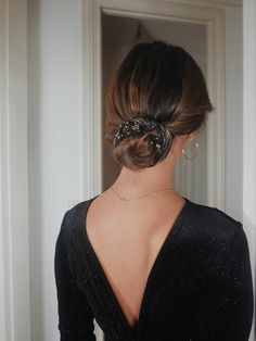 the back of a woman's head wearing a black dress