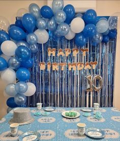 a blue and white birthday party with balloons