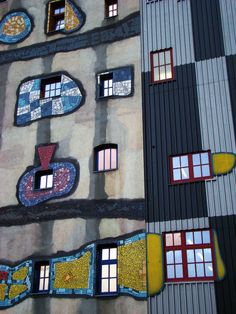 the side of a building with many windows and designs painted on it's sides