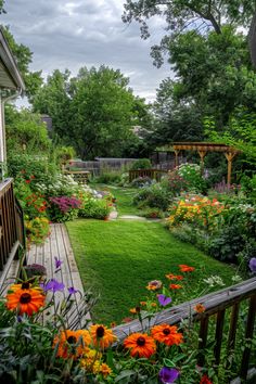 an outdoor garden with flowers and trees in the background, along with a wooden deck