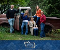 a group of people standing next to an old truck