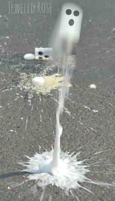 a white substance is spewing out from the ground in front of some toilet paper