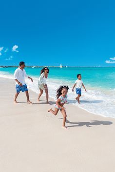 a group of people walking on top of a sandy beach