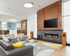 a living room with couches, chairs and a flat screen tv on the wall