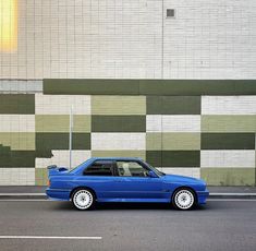 a blue car parked in front of a building