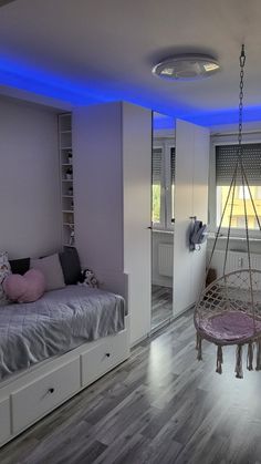 a bedroom with a hammock hanging from the ceiling next to a bed and window