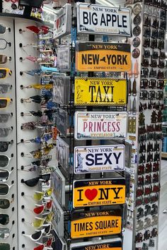 many signs are on display in a store with glasses and other items for sale behind them