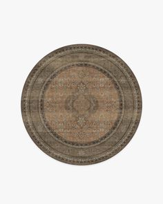 a round rug with an intricate design on the center and sides, in brown tones