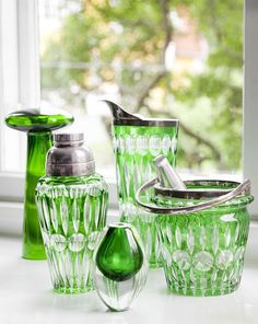 green glass bathroom accessories sitting on a window sill