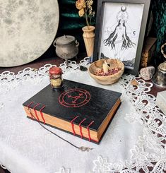 an old book sitting on top of a table next to some jars and vases