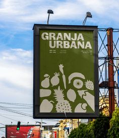 a large sign hanging from the side of a building next to traffic lights and power lines