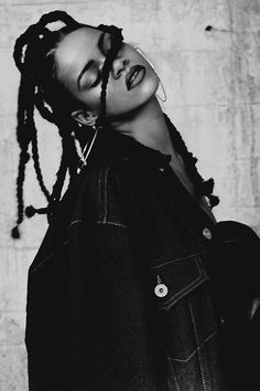 a black and white photo of a woman with dreadlocks on her head wearing a denim jacket