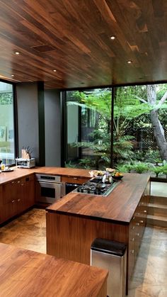 an open kitchen with wooden cabinets and stainless steel appliances in front of a large window