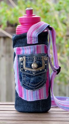 a pink and blue striped bag with a water bottle in the pocket on a wooden table