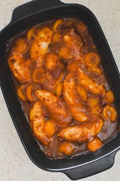 chicken with sauce in a black dish on a counter