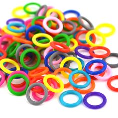 many different colored plastic rings on a white surface