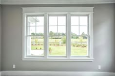 an empty room with three windows and no curtains on the window sill in front of it