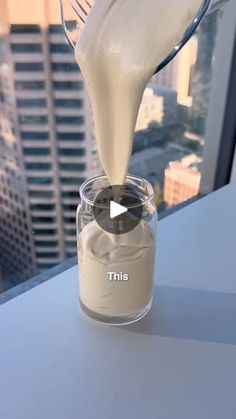 milk being poured into a glass container on top of a building