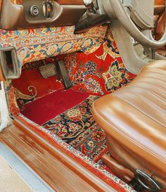 the interior of an old car with leather seats and carpeted flooring is shown