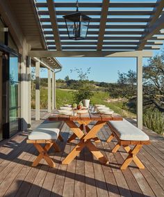 an outdoor table and bench on a wooden deck