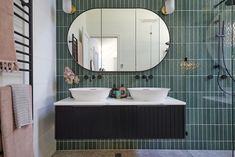 a bathroom with two sinks and a large mirror on the wall above it's counter