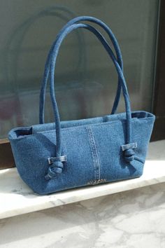 a blue purse sitting on top of a window sill