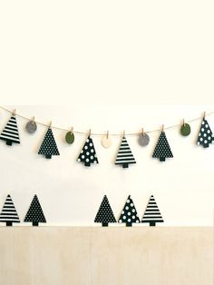 black and white christmas trees are hanging on a string with polka dot balls around them