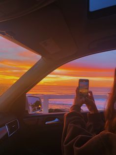 a person taking a photo in the back seat of a car with their cell phone