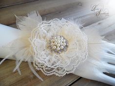 a bridal garter with white feathers and pearls on the headband, sitting on a wooden surface