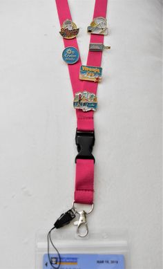 a pink lanyard with badges attached to it