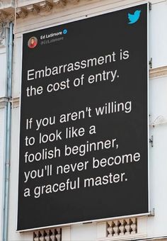 a sign on the side of a building that says,'embarrastment is the cost of entry if you aren't wiling to look like a fool