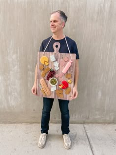 a man wearing an apron made to look like he is holding a board with food on it