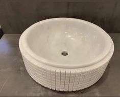 a white sink sitting on top of a gray counter next to a black and white tiled wall