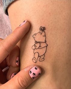 a woman's stomach with a small tattoo of a pooh bear