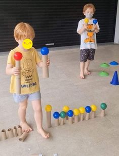 two young boys are playing with toys in the garage while another boy is standing behind them