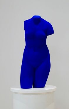 a blue sculpture sitting on top of a white pedestal