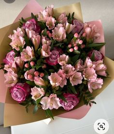 a bouquet of pink flowers sitting on top of a table