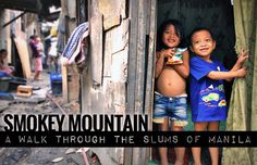 two young children are standing in the doorway of their shack, smiling at the camera