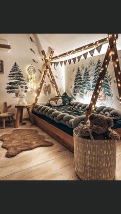 a bedroom decorated for christmas with lights on the ceiling and teddy bear sitting in bed